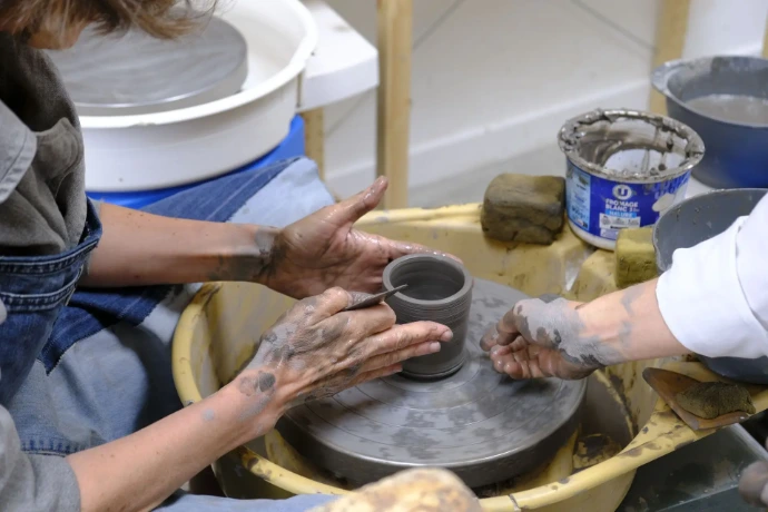 Les mains sur le tour de poterie