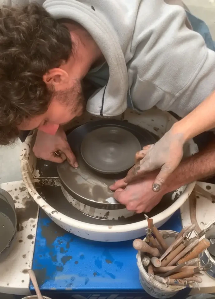 Jeune homme sur le tour de poterie