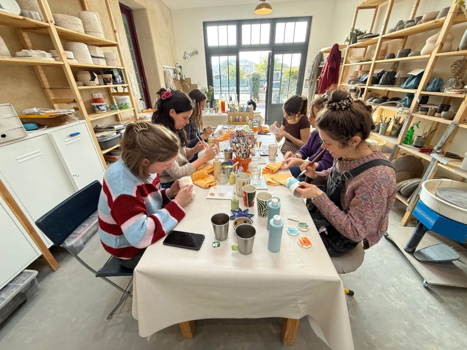 Un groupe de jeunes femmes participent à un enterrement de vive de jeune filles (EVJF) au café céramique de l'atelier Skaal. l'atelier Skaal